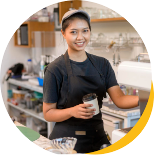 Happy female restaurant owner and Hubbo POS customer in kitchen with cap, holding a white cup.